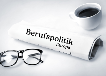 Zeitung auf weißem Untergrund mit Brille und Kaffeetasse